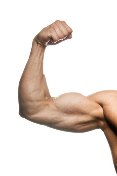 Close-up of a power fitness man's hand. Muscular bodybuilder flexing and showing his biceps - internal side - on white background. Studio shot. - Zdjęcie, obraz