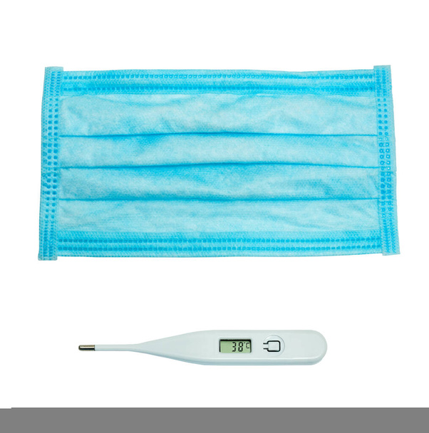 Weißes Thermometer und blaue medizinische Maske isoliert auf weißem Hintergrund. Schutz vor Umweltverschmutzung und Viren. Gesundheitskonzept - Foto, Bild