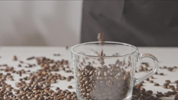 Fragrant coffee beans pouring into cup - Filmati, video