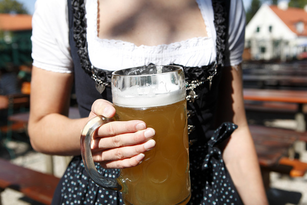 fiatal nő gazdaság egy korsó sör a kerthelyiségben - Fotó, kép