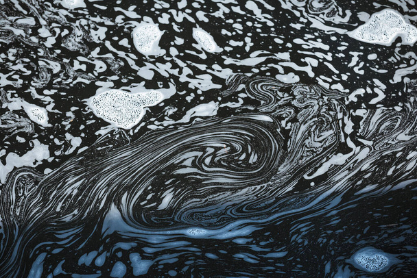 Foam spirals shapes on the water close-up view. Dark blue spring water with white foam structures - Foto, imagen