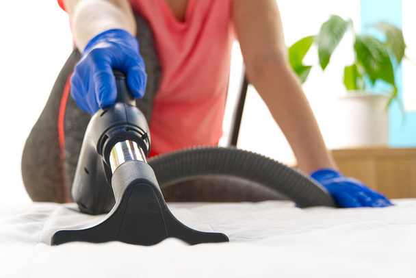 Vacuuming bed. Domestic home cleaning concept. Textile sofa chemical cleaning. Upholstered furniture. Early spring cleaning or regular clean up. Cleaning Service conceptatHome, apartments, hotels - Valokuva, kuva