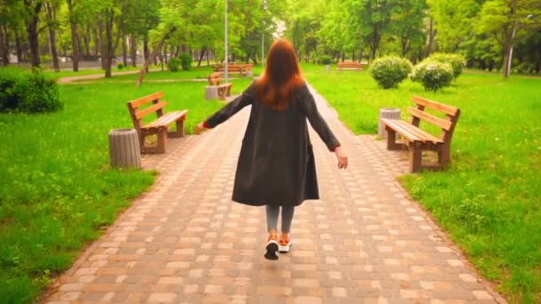 mujer feliz con el pelo rojo camina en el parque
 - Metraje, vídeo