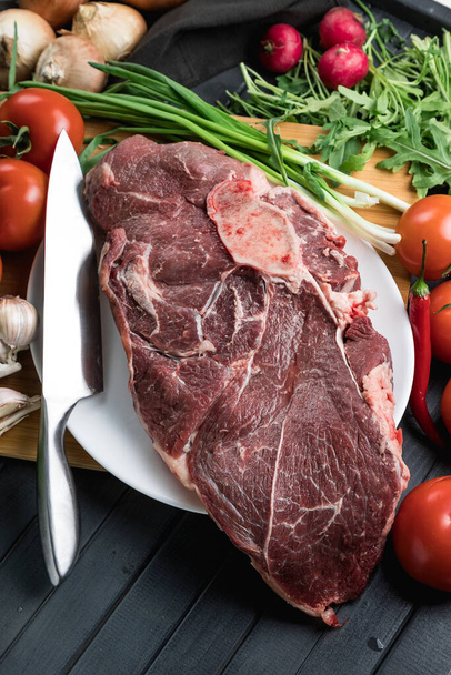 A juicy piece of fresh meat. Meat and vegetables. Cooking meat. A chef's knife. Balanced diet. Red meat. - Foto, imagen