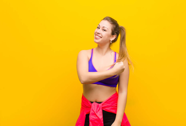 young blonde woman feeling happy, positive and successful, motivated when facing a challenge or celebrating good results. sport concept - 写真・画像