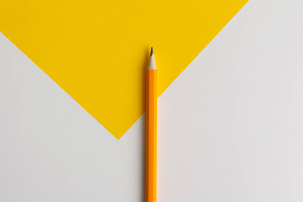 An interactive photo composition of an orange pencil and space for creative thinking (text) is used for presentation in the field of education, business or creativity. Lighting on a pencil in the studio. Yellow white background - Photo, image
