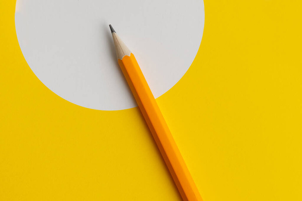 An interactive photo composition of an orange pencil and space for creative thinking (text) is used for presentation in the field of education, business or creativity. Lighting on a pencil in the studio. Yellow white background - Foto, Bild