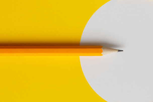 An interactive photo composition of an orange pencil and space for creative thinking (text) is used for presentation in the field of education, business or creativity. Lighting on a pencil in the studio. Yellow white background - Fotoğraf, Görsel