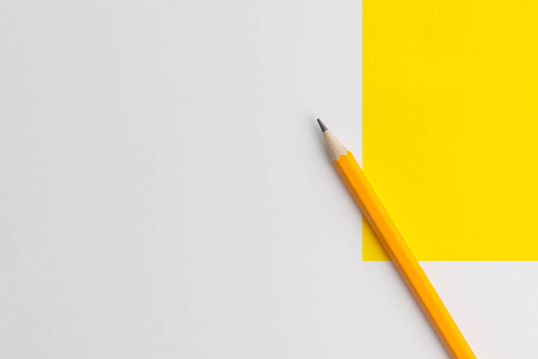 Yaratıcı düşünce (metin) için bir turuncu kalem ve alanın etkileşimli fotoğraf kompozisyonu eğitim, işletme veya yaratıcılık alanında sunum için kullanılır. Stüdyoda kalemle aydınlatma. Sarı beyaz arkaplan - Fotoğraf, Görsel