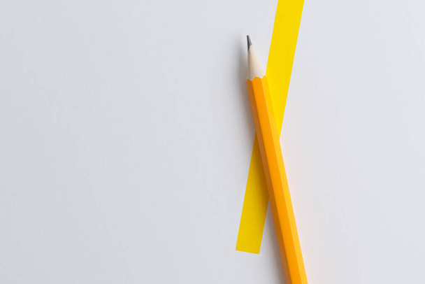 An interactive photo composition of an orange pencil and space for creative thinking (text) is used for presentation in the field of education, business or creativity. Lighting on a pencil in the studio. Yellow white background - Фото, зображення