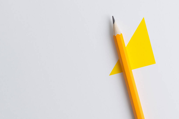 An interactive photo composition of an orange pencil and space for creative thinking (text) is used for presentation in the field of education, business or creativity. Lighting on a pencil in the studio. Yellow white background - Photo, Image