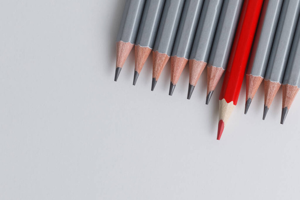 red pencil and gray pencils on a white paper background. Leader concept, different, unique - 写真・画像