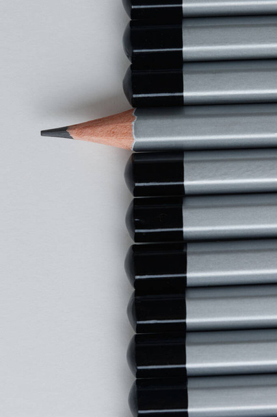 One gray pencil unfolded the sudden side in a number of other pencils. Financial business competition concept. - 写真・画像