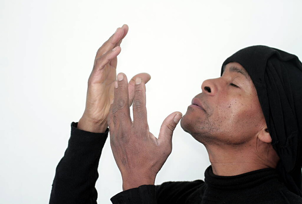 Mann betet zu Gott mit Händen zusammen Karibik Mann betet mit weißem Hintergrund Archivfoto - Foto, Bild