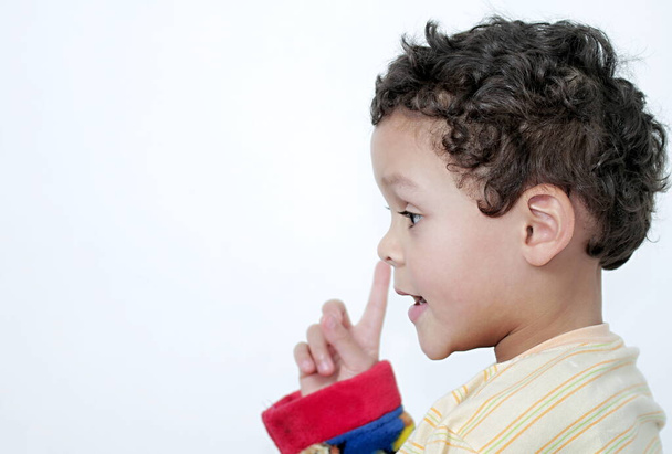 jongen peuteren zijn neus en plezier hebben met witte achtergrond stock foto - Foto, afbeelding