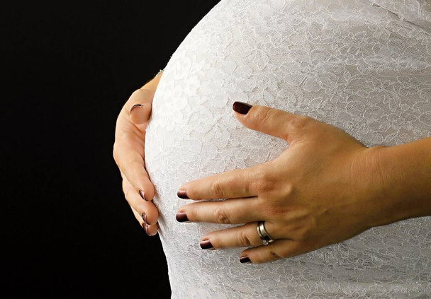 femme enceinte avec les mains sur le ventre caressant son bébé avec amour et soin sur fond blanc photo de stock
 - Photo, image