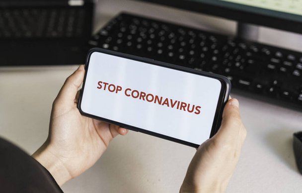 Stop coronavirus. Put your message on the phone. Hands of a woman holding a mobile phone with a blank screen to put a text message or advertising content. Social distance. Coronavirus devices. Social distancing. Protection against pandemics - Zdjęcie, obraz