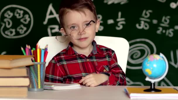 Cute child boy doing homework. Clever kid drawing at desk. Schoolboy. Elementary school student drawing at workplace. Kid enjoy learning. Home schooling. Back to school. Little boy at school lesson - Πλάνα, βίντεο