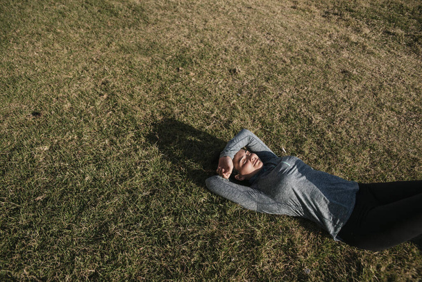 fille caucasienne se reposant après l'entraînement. Athlète couché sur l'herbe. Mode de vie sain. Espace de copie
. - Photo, image