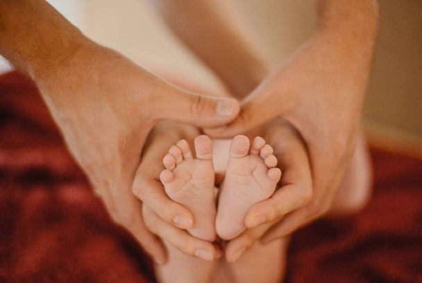 Ruce mámy a táty drží miminko za nohy - Fotografie, Obrázek