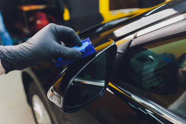 Auto-Details - Mann trägt Nano-Schutzschicht auf das Auto auf. Selektiver Fokus. - Foto, Bild