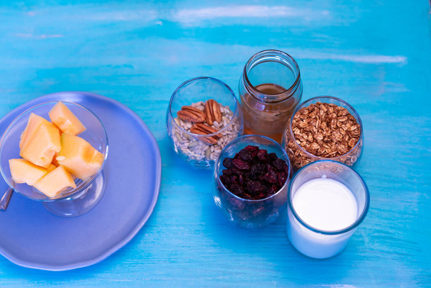 Кусочки дыни, на голубом столе с голубой тарелкой и семенами
. - Фото, изображение