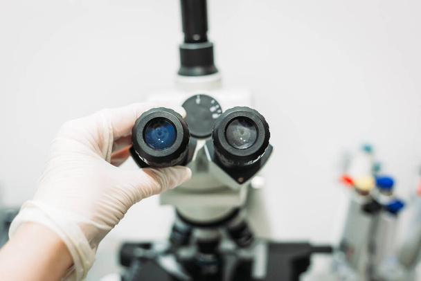 Medical worker holding microscope ocular in the lab. Lab equipment, science research - Φωτογραφία, εικόνα