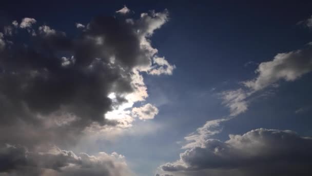 Όμορφο χρονικό διάστημα 4K. Οι ακτίνες του ήλιου διαπερνούν λευκά χνουδωτά σύννεφα στον γαλάζιο ουρανό - Πλάνα, βίντεο
