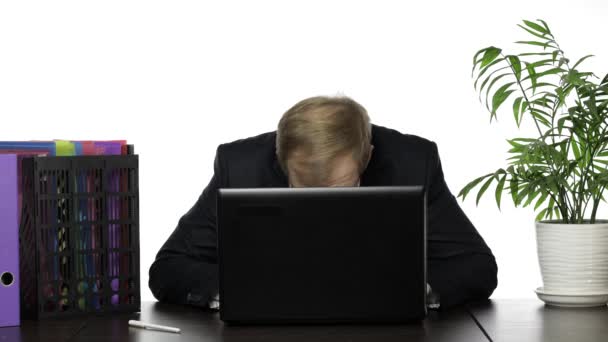 Businessman manager chowa się za laptopem i wygląda podczas pracy w biurze - Materiał filmowy, wideo