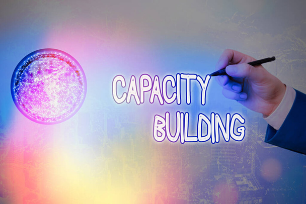 Writing note showing Capacity Building. Business photo showcasing Strengthen the abilities of individuals Workforce planning Elements of this image furnished by NASA. - Photo, Image
