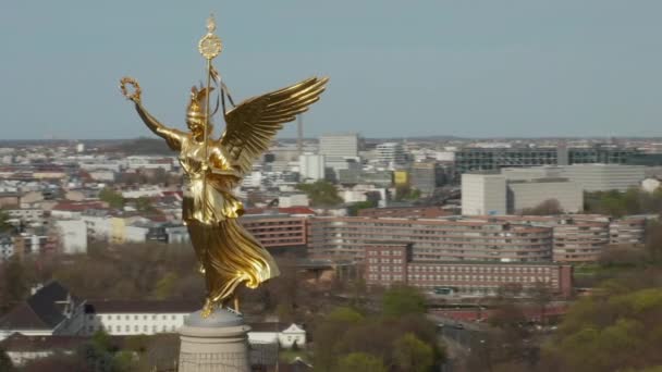 AERIAL: Close Up Circuit rond de Berlijnse Victory Column Golden Statue Victoria in mooi zonlicht en Brandenburger Tor op de achtergrond  - Video