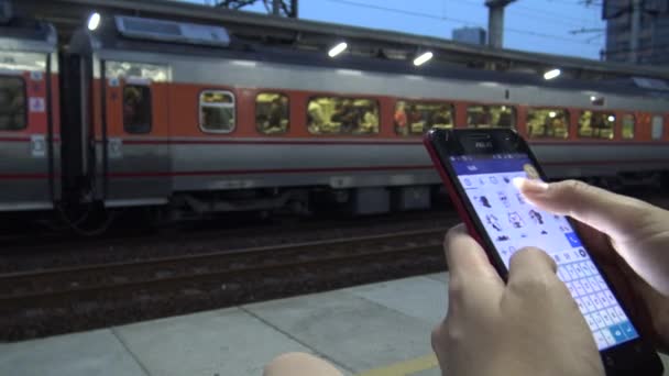 4K Hd Ultra, молодая азиатка с помощью смартфона на активной платформе метро. Когда проходит поезд, женщина проверяет социальную сеть и пишет текст на своем телефоне, на платформе железнодорожного вокзала Тайваня - Дэн
 - Кадры, видео