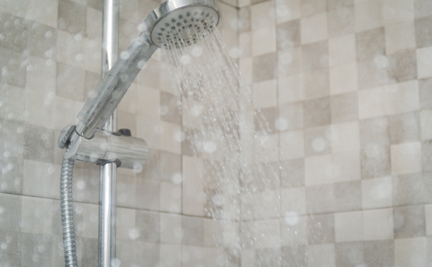 Friss zuhany a vizes üveg ablak mögött, cseppek fröcskölnek. Zuhanyozó fejből folyó víz. - Fotó, kép