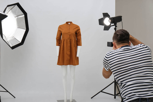 Professional photographer taking picture of ghost mannequin with stylish clothes in modern photo  - 写真・画像