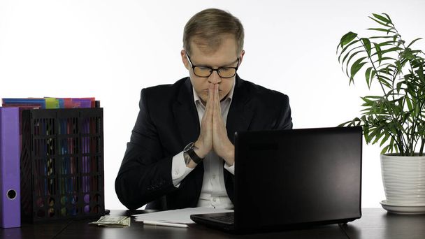 Jóképű fiatal üzletember menedzser imádkozik várja a jó eredményt a munkáját - Fotó, kép