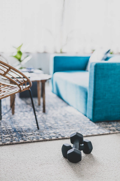 home gym and exercising indoor concept, set of fitness gear on living room carpet next to the couch in a living room shot at shallow depth of field - Φωτογραφία, εικόνα