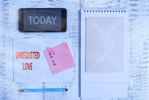 Conceptual hand writing showing Unrequited Love. Business photo showcasing not openly reciprocated or understood as such by beloved Spiral notebook marker smartphone sticky wood background. - Photo, Image