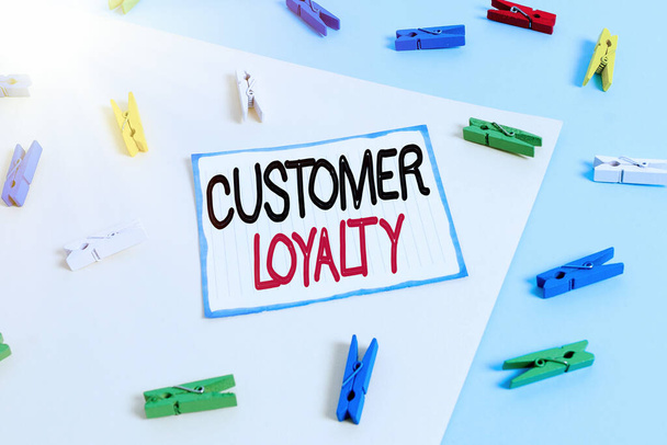 Conceptual hand writing showing Customer Loyalty. Business photo text result of consistently positive emotional experience Colored clothespin paper reminder with yellow blue background. - Photo, Image