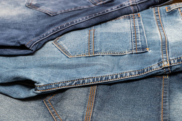 Close-up van de blauwe denim textuur. Denim jeans achtergrond, ruimte om uw ontwerp of tekst te kopiëren. - Foto, afbeelding