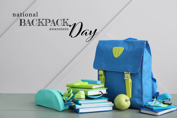 Σχολική τσάντα και χαρτικά στο τραπέζι με γκρι φόντο. Εθνική Ημέρα Ενημέρωσης Σακίδιο - Φωτογραφία, εικόνα