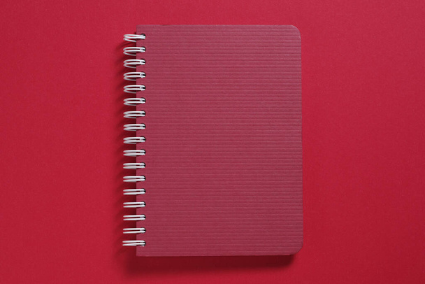 Dark red notebook with spiral close-up, top view - Foto, Bild