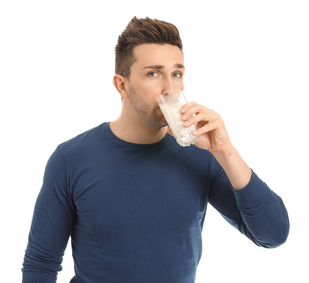 Mladý muž se sklenicí mléka na bílém pozadí - Fotografie, Obrázek