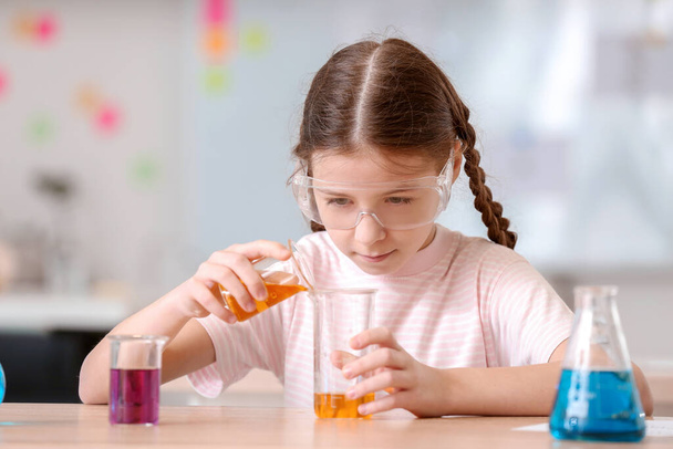 Pieni tyttö kemian oppitunti luokkahuoneessa
 - Valokuva, kuva