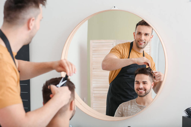 männlicher Friseur arbeitet mit Klient im Salon - Foto, Bild