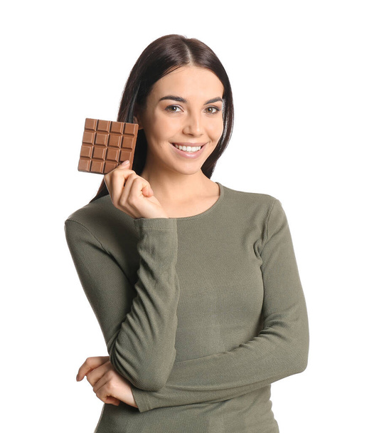 Bella giovane donna con gustoso cioccolato su sfondo bianco - Foto, immagini