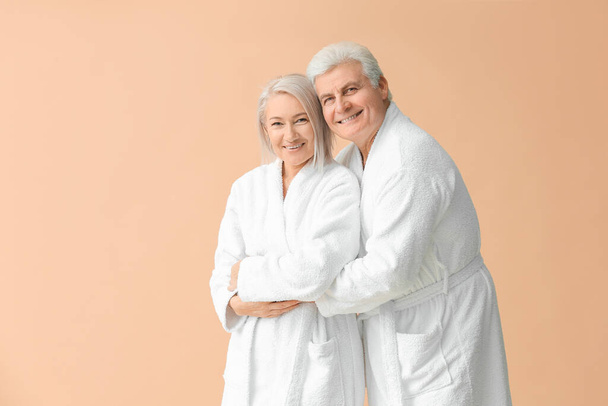 Ältere Paare in Bademänteln auf farbigem Hintergrund - Foto, Bild