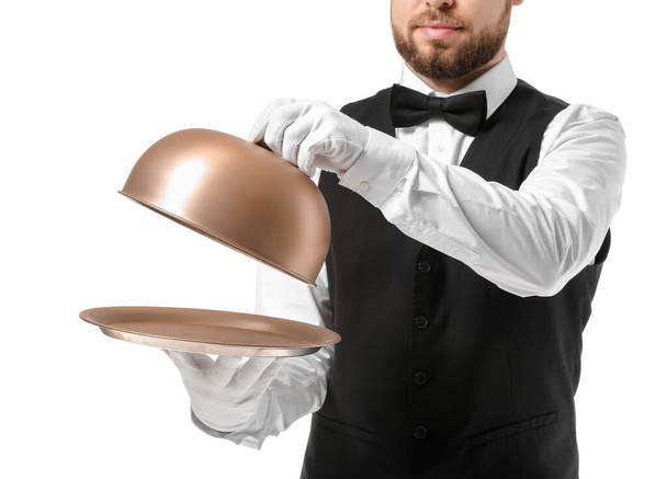 Schöner männlicher Kellner mit Tablett und Cloche auf weißem Hintergrund - Foto, Bild