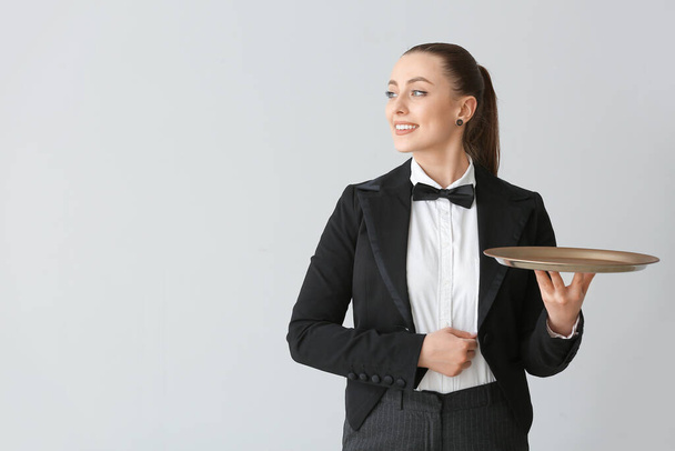 Cameriere donna con vassoio vuoto su sfondo grigio
 - Foto, immagini