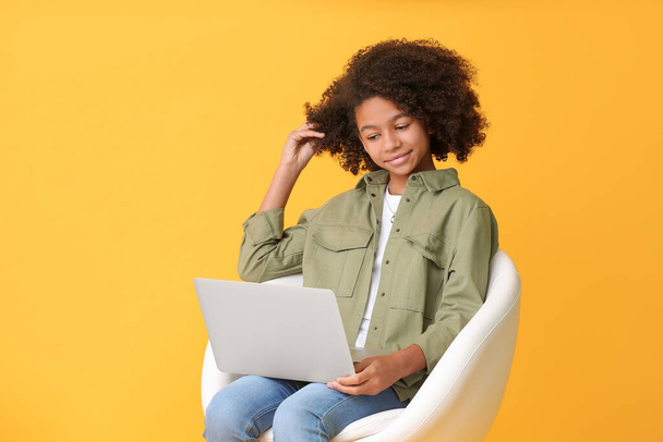 African-American teenage blogger with laptop on color background - Φωτογραφία, εικόνα