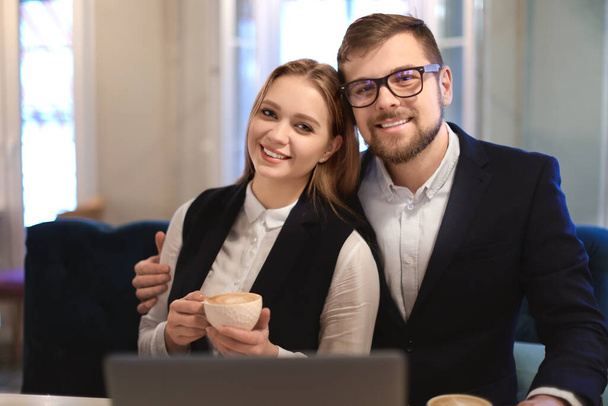 Young business people drinking coffee during work in cafe - Photo, Image